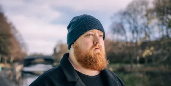 Bearded white man in a woolen hat looking serious